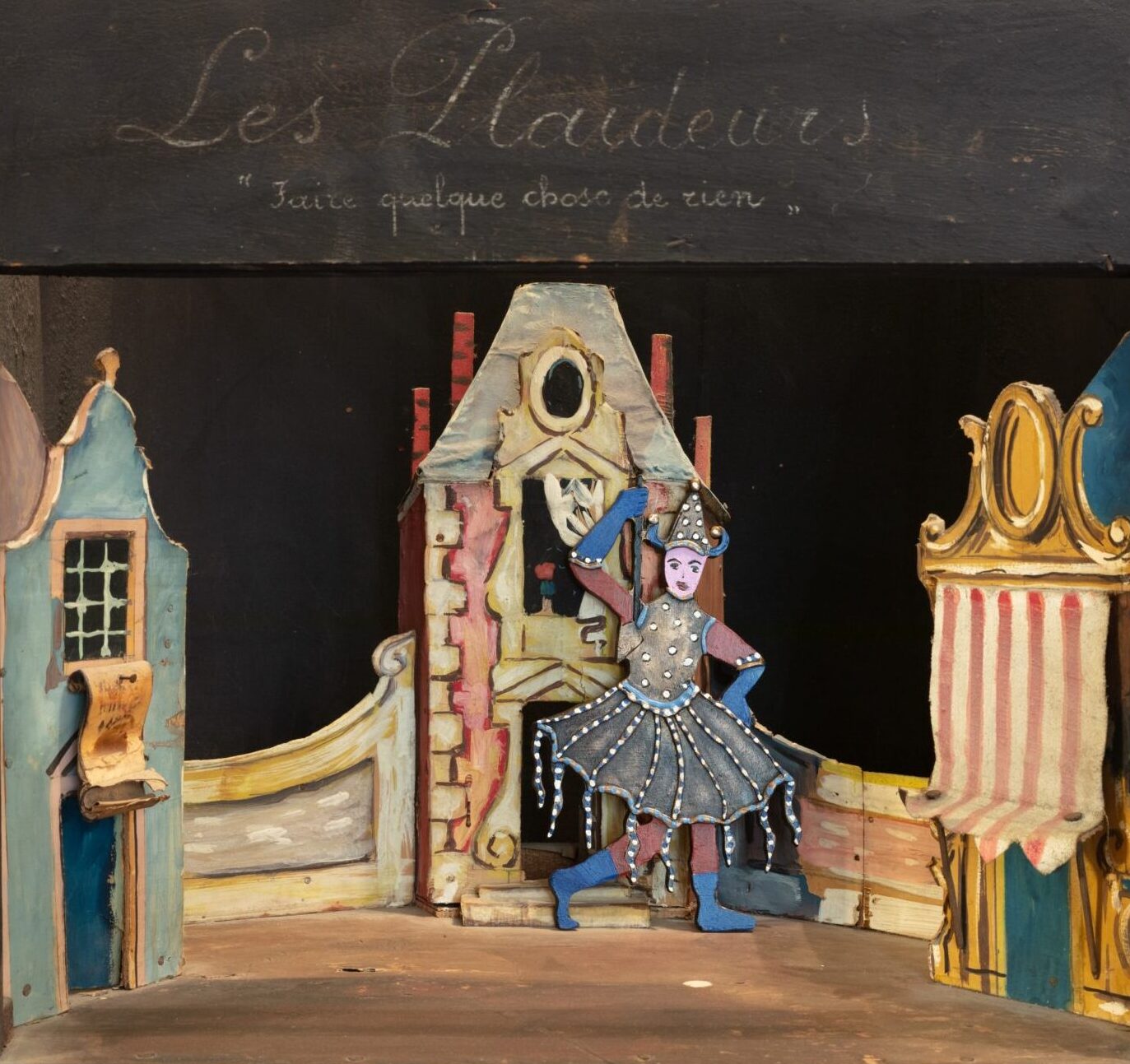 Painted bronze figurine inside miniature paper theatre